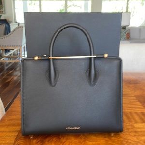 Strathberry midi tote bag black with top handle and shoulder strap.